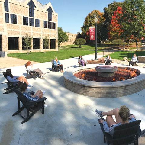 Students gathered around the campus fire pit