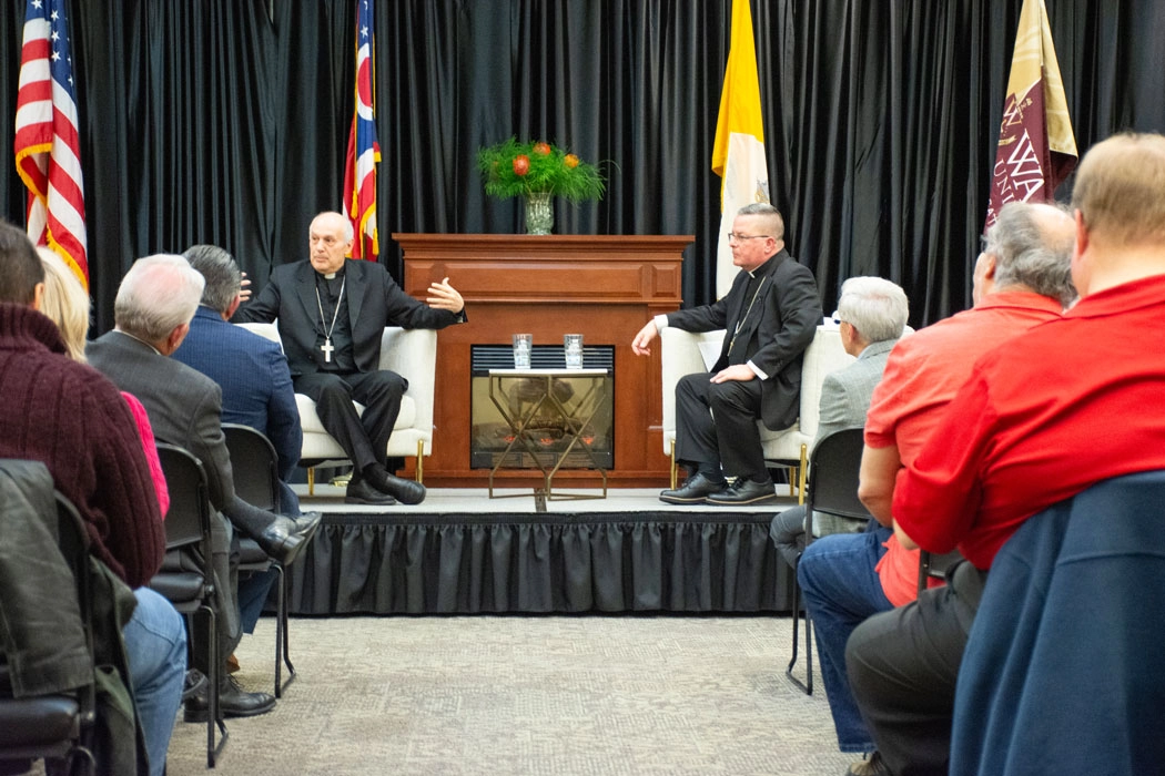 photo of Archbishop Caccia and Bishop Bonnar speaking on stage