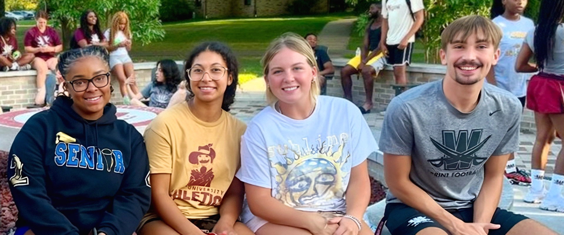 photo of four students sitting on the Alumni fire pit