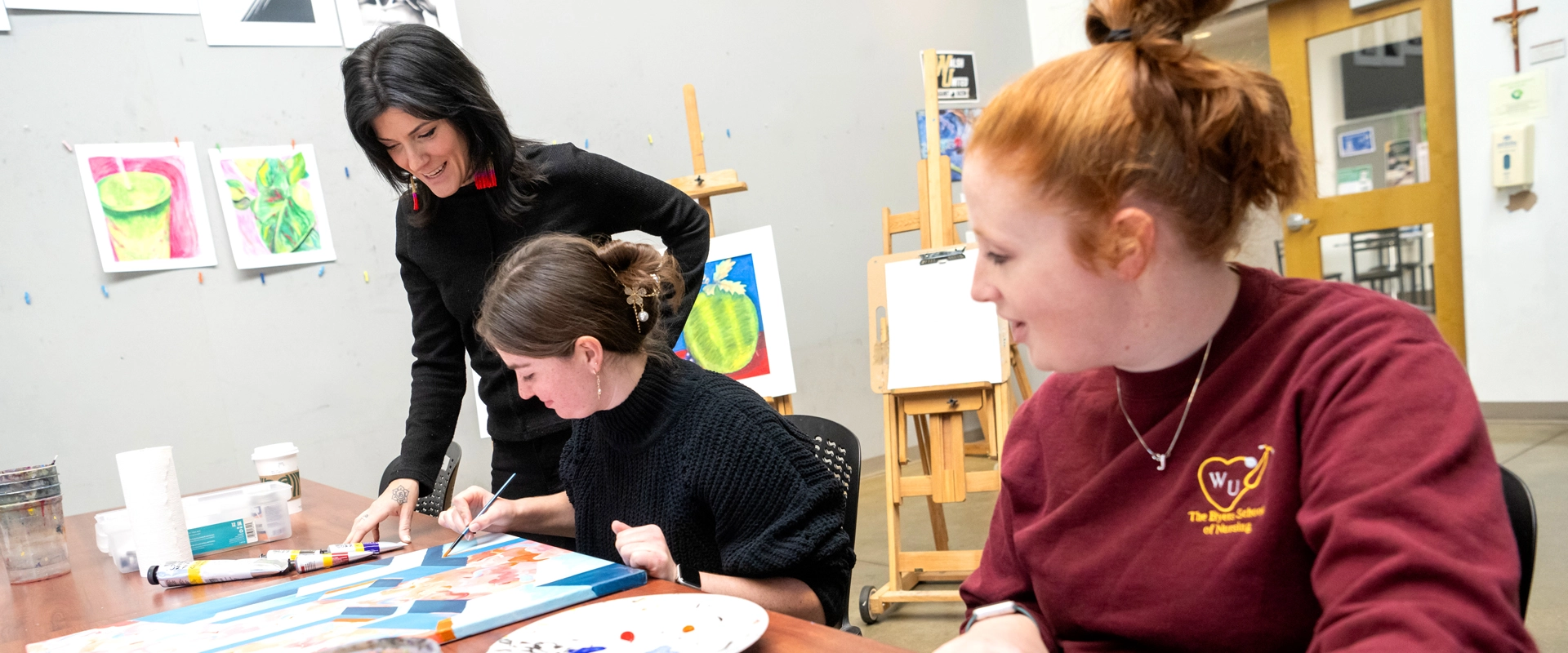 photo of two students and their professor in an art class