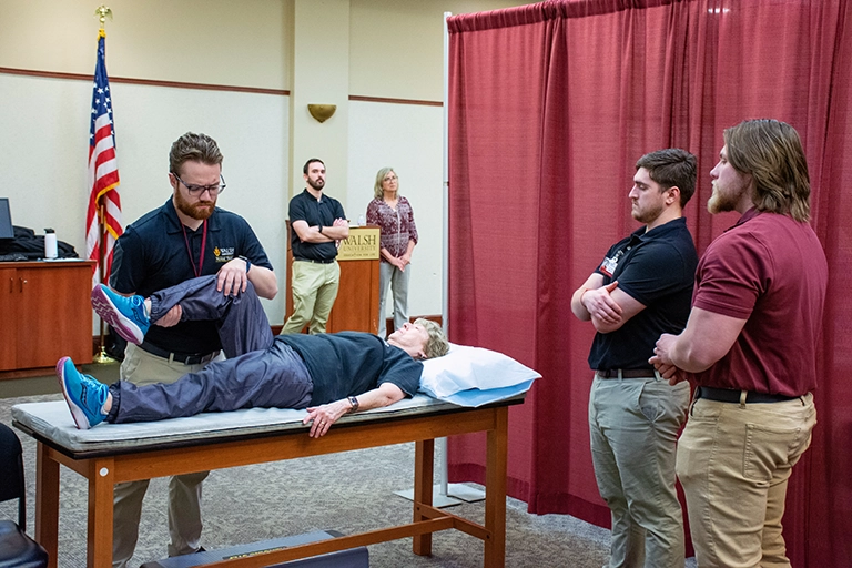 Photo of a Walsh PT student examining a patients knee flexion