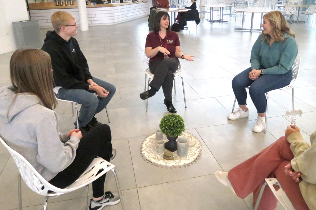 Photo of Walsh Faculty member, Dr. Michelle Bemiller, and a group of students having a discussion