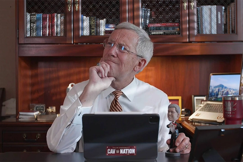 Photo of President Collins sitting at his desk thinking